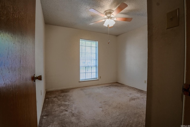 empty room with a textured ceiling, carpet, and a ceiling fan
