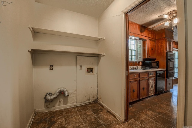 clothes washing area with hookup for a washing machine, hookup for an electric dryer, a textured ceiling, a ceiling fan, and baseboards