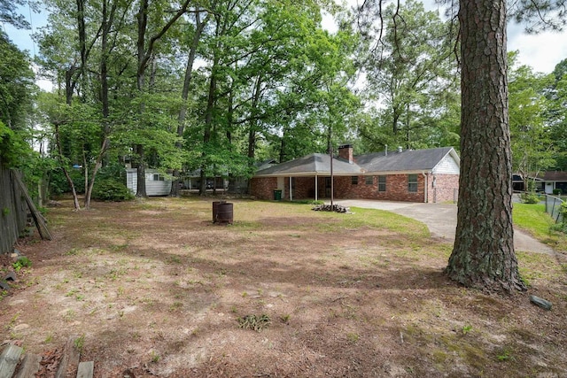view of yard featuring fence, an outdoor structure, a storage shed, and driveway