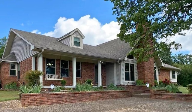 1000 Grandview Heights Dr, Conway, AR 72032 - new england style home with covered porch, roof with shingles, and brick siding