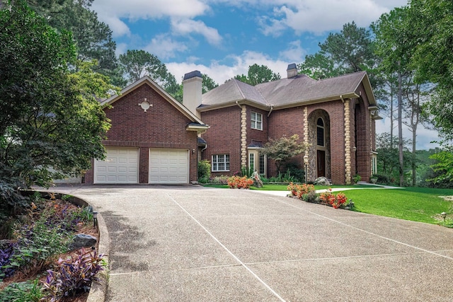 12 Loyola Ln, Hot Springs Village, AR 71909 - traditional home featuring a chimney, brick siding, driveway, a front lawn, and an attached garage