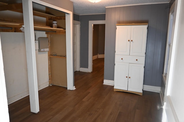 1304 W 9th St, North Little Rock, AR 72114 - unfurnished bedroom with dark wood-style floors, multiple closets, ornamental molding, a textured ceiling, and baseboards