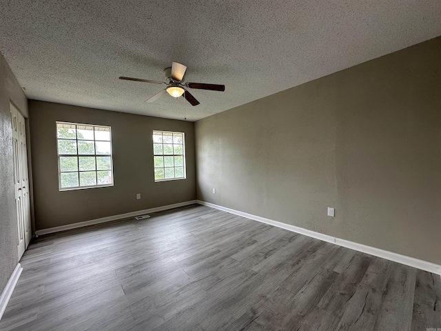 1720 Sanford Dr, Little Rock, AR 72227 - empty room featuring dark wood-style flooring, a textured ceiling, ceiling fan, and baseboards