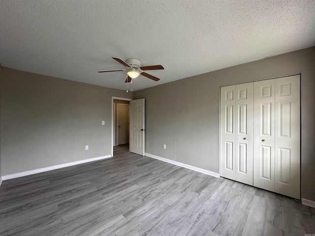 1720 Sanford Dr, Little Rock, AR 72227 - unfurnished bedroom featuring wood finished floors, baseboards, a closet, a textured ceiling, and ceiling fan