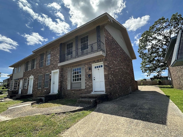 1720 Sanford Dr, Little Rock, AR 72227 - view of front facade with brick siding, a balcony, fence, and driveway