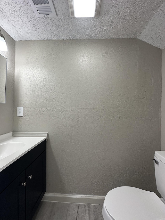 1720 Sanford Dr, Little Rock, AR 72227 - bathroom with toilet, wood finished floors, vanity, baseboards, and lofted ceiling