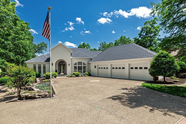 5 Granada Ln, Hot Springs Village, AR 71909 - view of front of house with french doors, a garage, concrete driveway, a shingled roof, and stucco siding