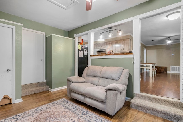 718 Jones St, Sheridan, AR 72150 - living area with a ceiling fan, light wood-style floors, baseboards, and crown molding