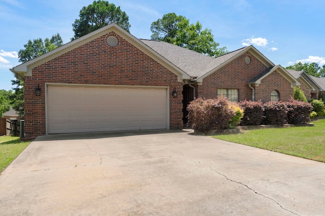 ranch-style house with brick siding, a garage, concrete driveway, a front yard, and roof with shingles