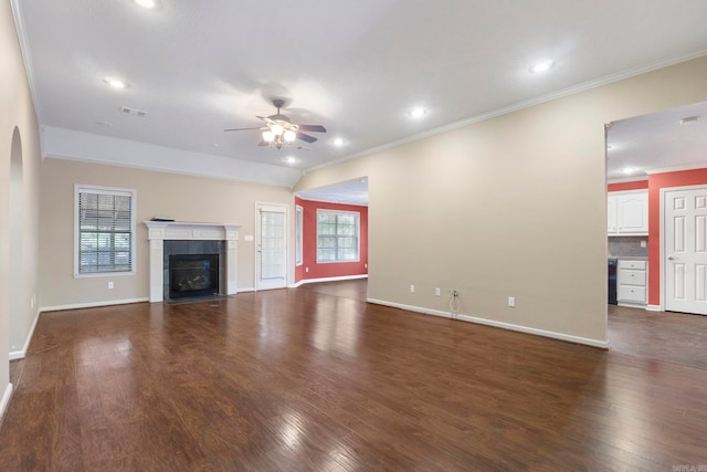 unfurnished living room featuring ornamental molding, a ceiling fan, baseboards, dark wood-style flooring, and a tile fireplace