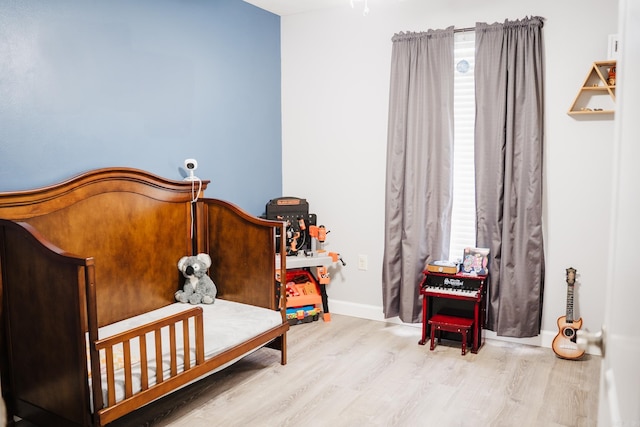 bedroom featuring wood finished floors and baseboards