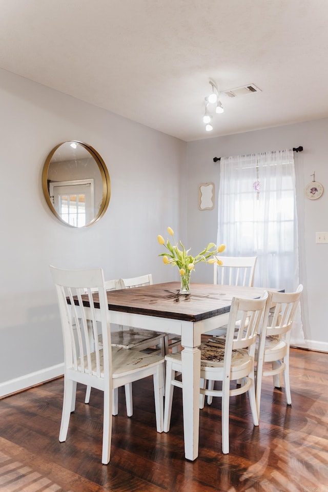dining space featuring wood finished floors and baseboards