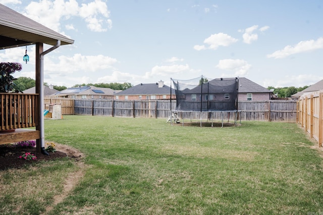 view of yard with a trampoline and a residential view