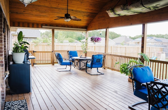 sunroom / solarium featuring a ceiling fan, vaulted ceiling, and a residential view