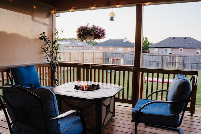 wooden terrace with a fire pit and a residential view