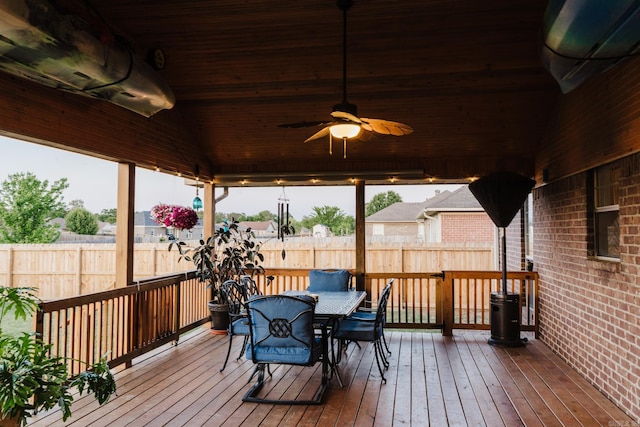 wooden terrace featuring outdoor dining space, ceiling fan, and fence