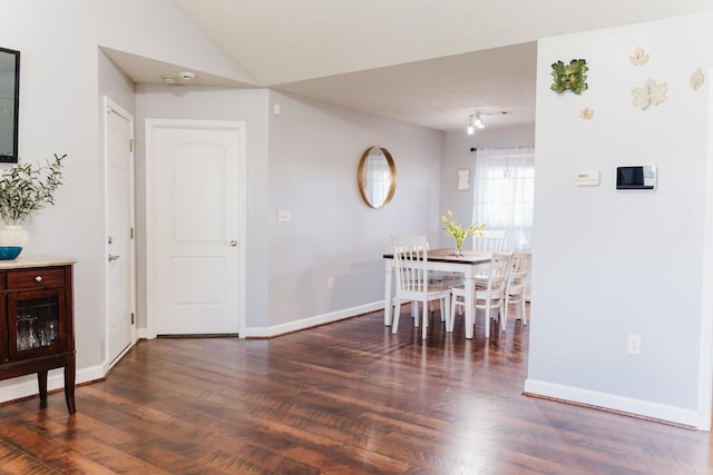 dining room featuring wood finished floors, baseboards, and lofted ceiling