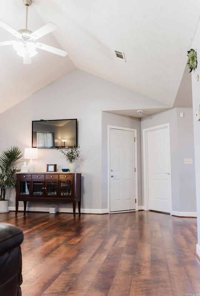 living area featuring vaulted ceiling, wood finished floors, ceiling fan, and baseboards