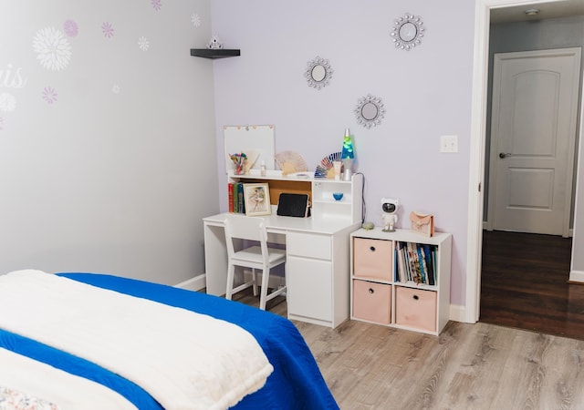 bedroom with light wood finished floors and baseboards
