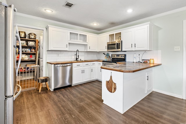 12 High Plains Dr, Cabot, AR 72023 - kitchen featuring stainless steel appliances, a peninsula, crown molding, open shelves, and dark wood-style floors