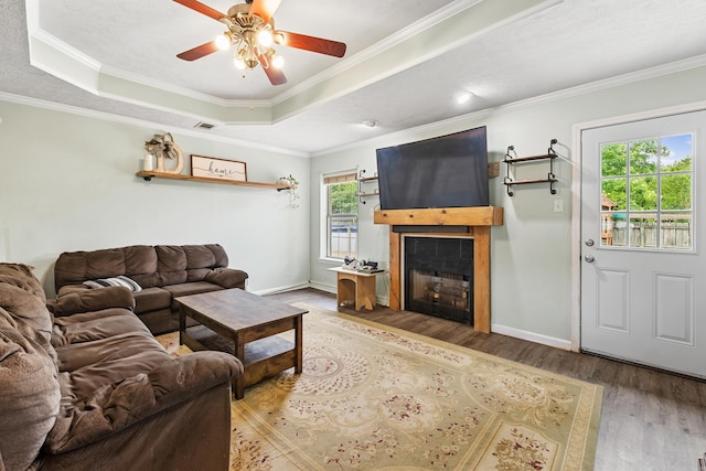 12 High Plains Dr, Cabot, AR 72023 - living area featuring wood finished floors, a fireplace, ceiling fan, ornamental molding, and a tray ceiling