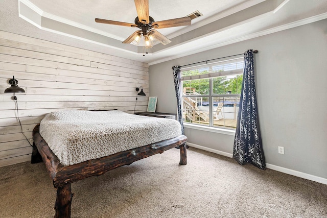 12 High Plains Dr, Cabot, AR 72023 - carpeted bedroom featuring a tray ceiling, ornamental molding, baseboards, wooden walls, and a ceiling fan