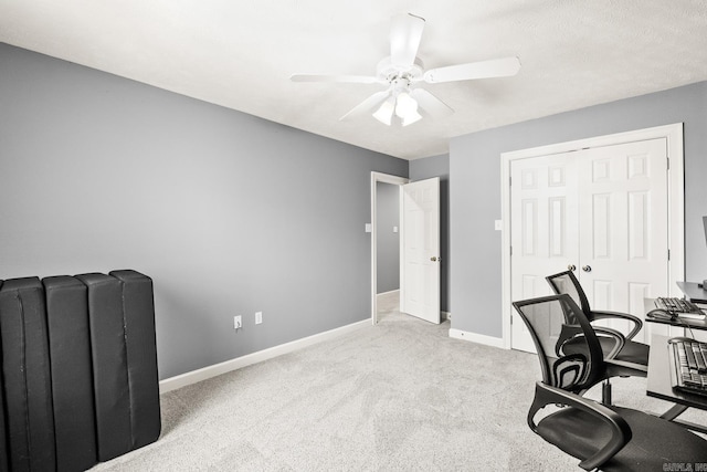 home office with ceiling fan, baseboards, and light carpet