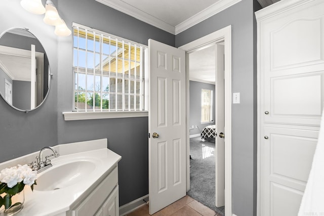 bathroom featuring crown molding, plenty of natural light, vanity, tile patterned flooring, and baseboards