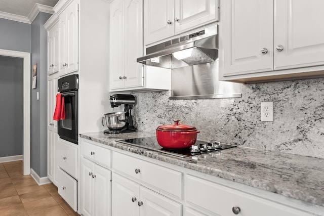 kitchen with under cabinet range hood, black appliances, ornamental molding, decorative backsplash, and light tile patterned floors