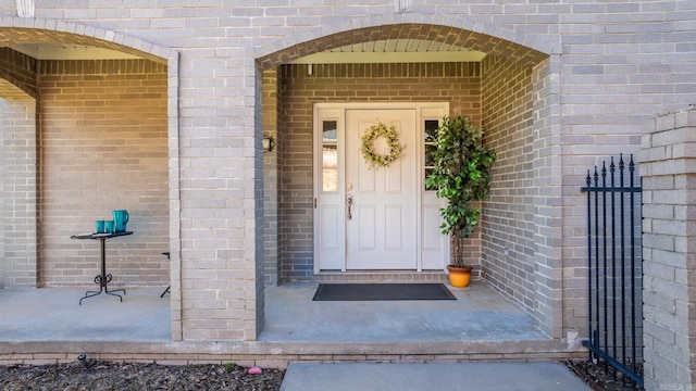 entrance to property featuring brick siding