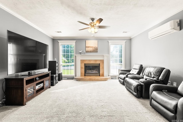 living area with an AC wall unit, a ceiling fan, healthy amount of natural light, crown molding, and carpet floors