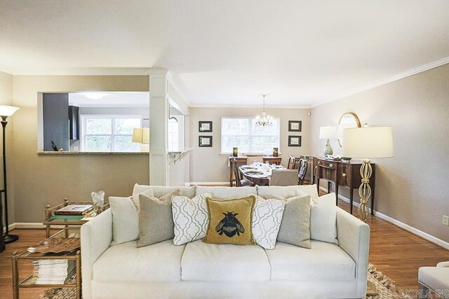 8113 Leatrice Dr, Little Rock, AR 72227 - living area featuring crown molding, wood finished floors, a chandelier, baseboards, and plenty of natural light