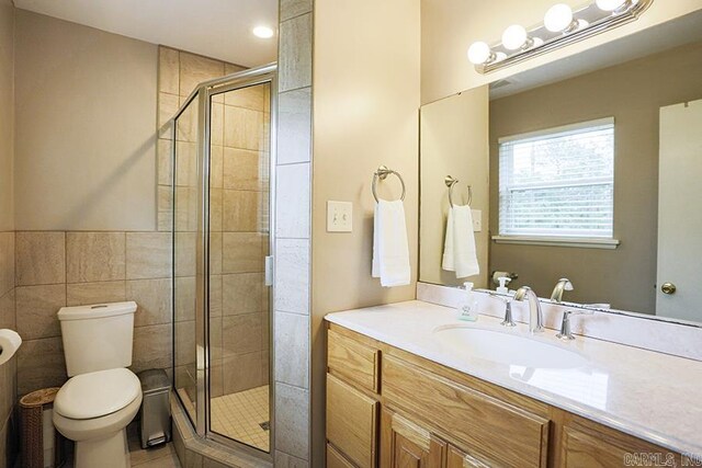 8113 Leatrice Dr, Little Rock, AR 72227 - full bath featuring toilet, a stall shower, tile patterned floors, vanity, and tile walls