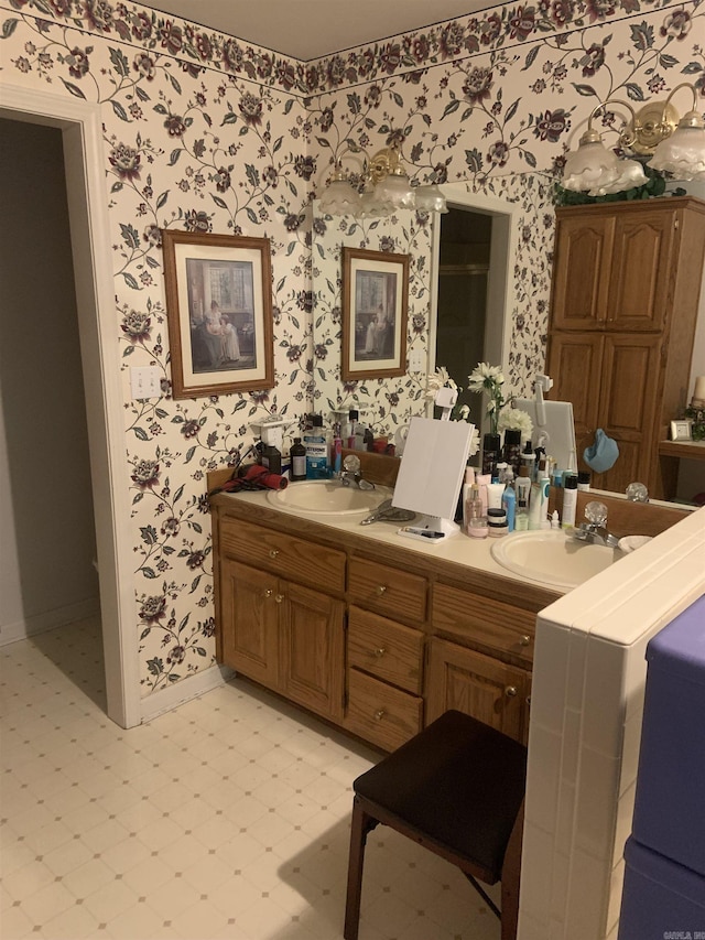 bathroom featuring wallpapered walls, tile patterned floors, baseboards, and double vanity