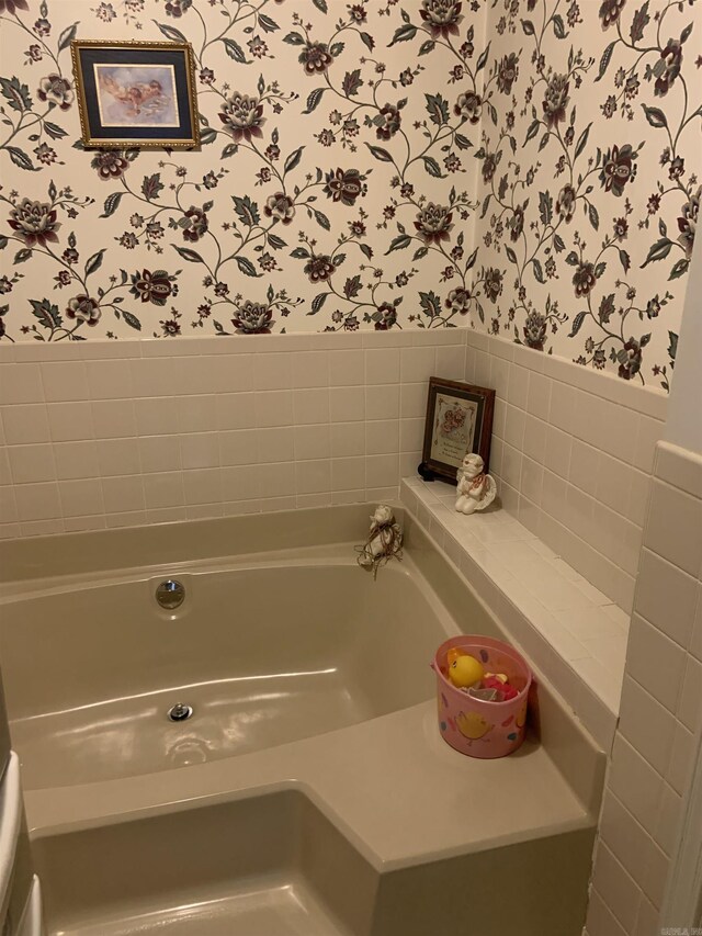 full bathroom featuring wallpapered walls and a garden tub