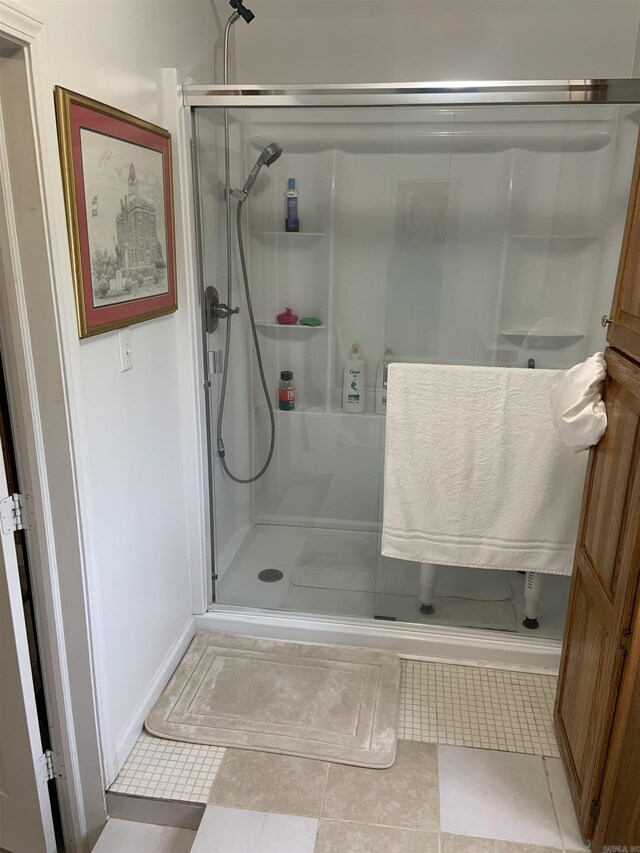 full bathroom featuring a shower stall, tile patterned floors, and baseboards