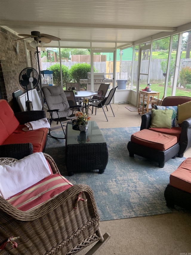 sunroom / solarium with ceiling fan, carpet flooring, and healthy amount of natural light