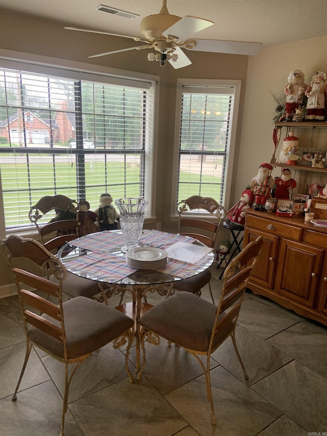 dining area with light tile patterned floors and a ceiling fan