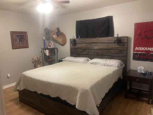 bedroom with wood finished floors, baseboards, and a ceiling fan
