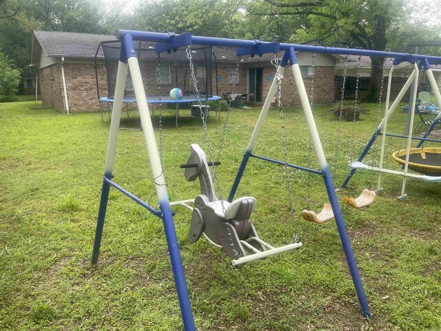 view of play area with a trampoline and a lawn