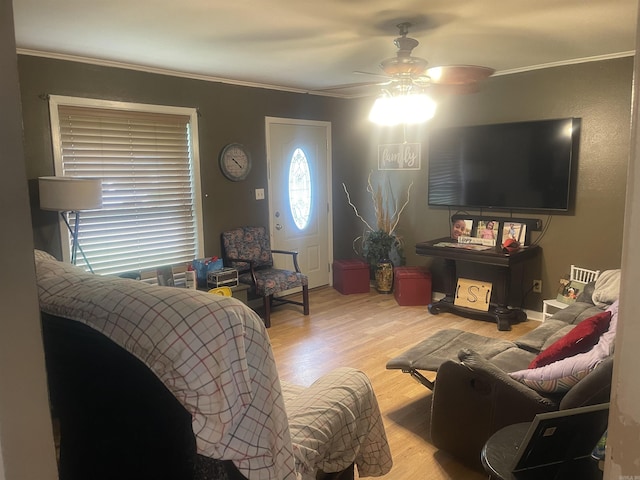 living area with ceiling fan, crown molding, and wood finished floors