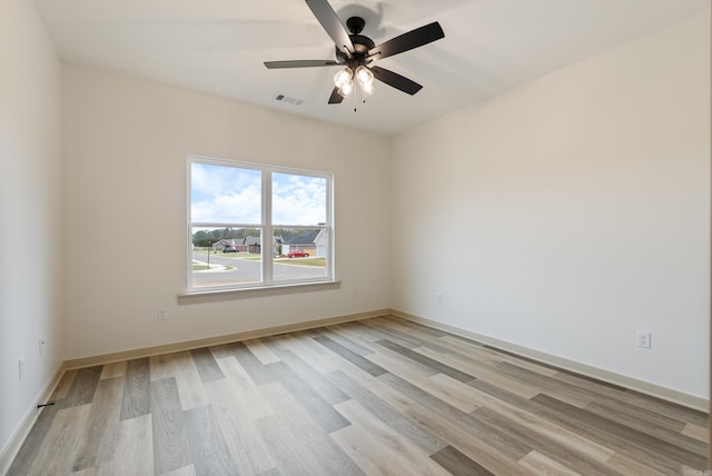 spare room with light wood-type flooring, ceiling fan, and baseboards