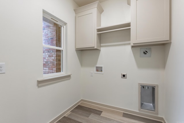 laundry area with hookup for an electric dryer, cabinet space, washer hookup, light wood-type flooring, and baseboards