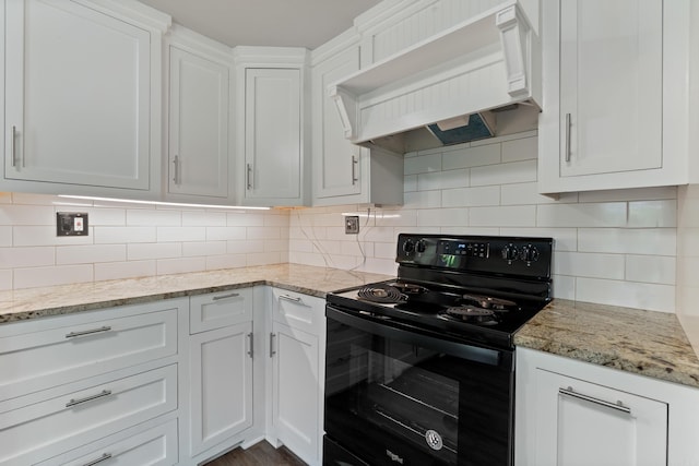 kitchen with black range with electric cooktop, custom range hood, white cabinets, and decorative backsplash