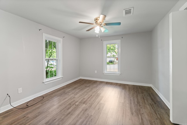 empty room featuring wood finished floors, ceiling fan, and baseboards