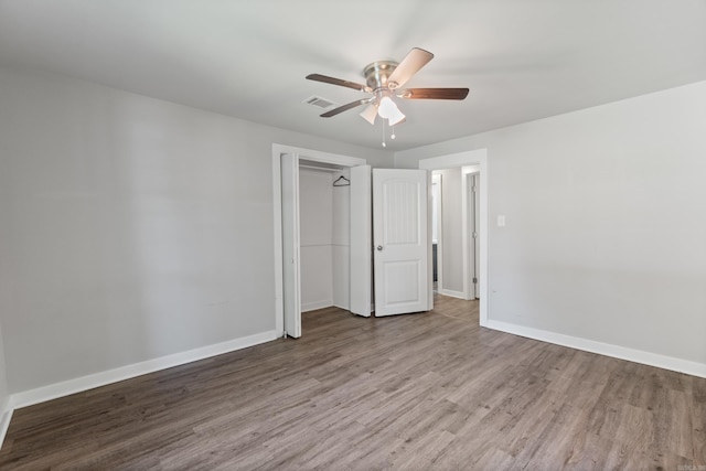 unfurnished bedroom with wood finished floors, baseboards, a closet, and ceiling fan