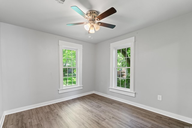 empty room featuring wood finished floors, baseboards, and ceiling fan