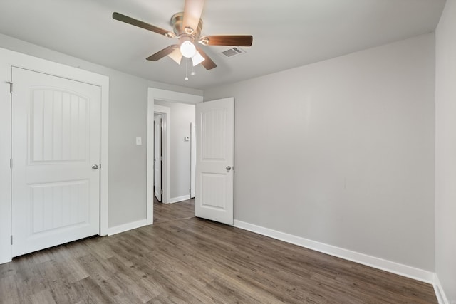 unfurnished bedroom featuring wood finished floors, baseboards, and ceiling fan