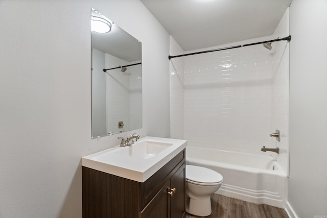 bathroom with wood finished floors, toilet, vanity, and bathtub / shower combination