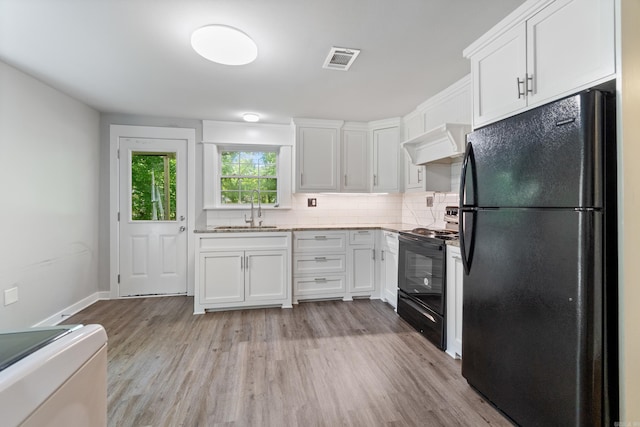 kitchen featuring black appliances, a sink, white cabinets, and light wood-type flooring